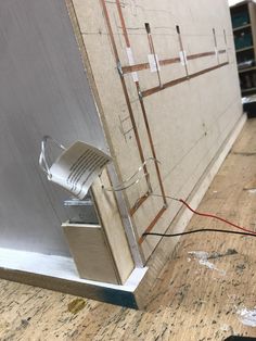 an electrical device connected to a wall in a room with wood flooring and walls