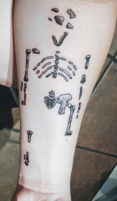 a person with a tattoo on their arm that has various objects in the shape of bones