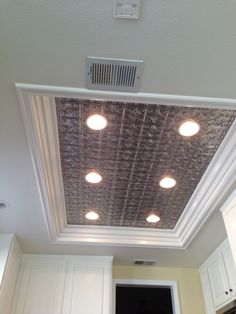 the ceiling in this kitchen has been painted white and is decorated with metallic foils