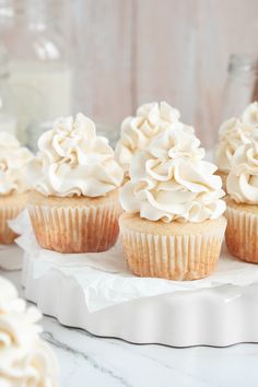 cupcakes with white frosting sitting on a plate