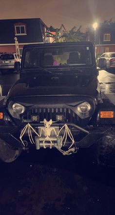 a jeep parked in a parking lot with its hood up and the front grill missing