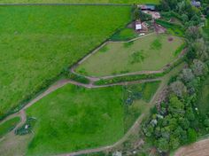 an aerial view of a green field and farm land