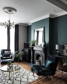 a living room filled with furniture and a fire place next to a large window on top of a hard wood floor