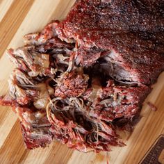 a large piece of meat sitting on top of a wooden cutting board