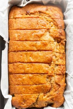 a loaf of bread sitting on top of a pan filled with batter and sliced into slices