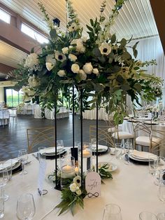 an elegant centerpiece with white flowers and greenery