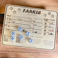 a wooden board game with blue dices and words on the side that says farkle