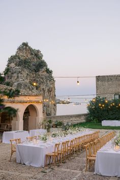 an outdoor dining area with tables and chairs set up in front of a stone building