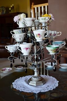 a table topped with lots of cups and saucers on top of a glass table