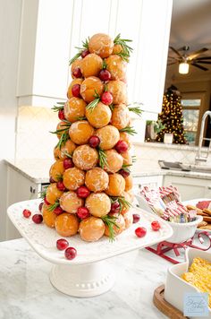 a christmas tree made out of doughnuts on a cake stand in a kitchen