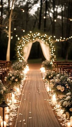 an outdoor ceremony with candles and flowers on the aisle, surrounded by greenery and lights