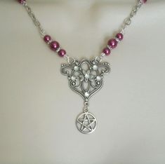 Pink Pentacle Necklace This beautiful necklace has pink glass pearl beads, seed beads, silver plated accent beads, silver plated chain, silver plated filigree pendant with rhinestones and a pewter silver pentacle. 20 inches long. Silver plated lobster clasp. The pendant is 1.5 inches wide and 1.5 inches long.  wiccan pagan wicca goddess witchcraft pentagram witch gothic witchy woman style Gothic Silver Beaded Necklace Perfect For Gifts, Silver Gothic Beaded Necklace For Gift, Silver Gothic Beaded Necklace As Gift, Gothic Silver Necklaces With Round Beads, Mystical Silver Necklace With Round Beads, Gothic Silver Necklace With Round Beads, Silver Gothic Necklaces With Round Beads, Handmade Pink Gothic Jewelry, Pink Gothic Jewelry