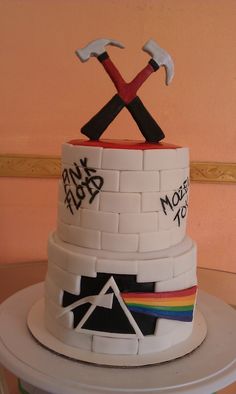 a multi - colored cake with two hammers on top