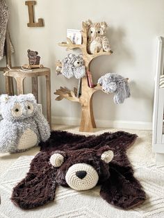 there are stuffed animals on the floor next to a teddy bear and an owl tree