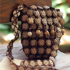 a purse sitting on top of a wooden table next to a piece of wood and beads