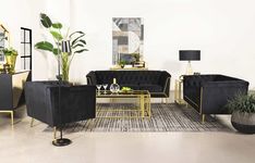 a living room filled with black couches and gold tables in front of a white wall