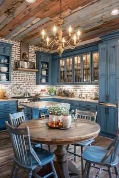 an old fashioned kitchen with blue cabinets and wood flooring, chandelier above the table