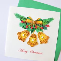 a christmas card with three bells and holly leaves on the front, decorated with bows