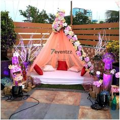 a bed with flowers on it in the middle of an outdoor ceremony area at night