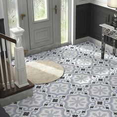 an entryway with blue and white tiles on the floor next to a door way