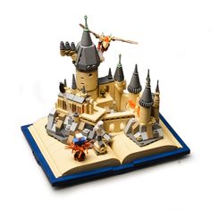 an open book with a model of a castle on it