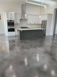 an empty kitchen with white cabinets and stainless steel appliances in the middle of the room