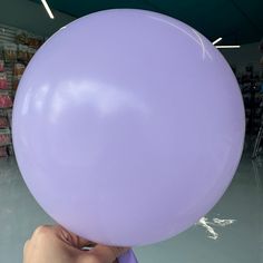 a person holding a large purple balloon in their hand