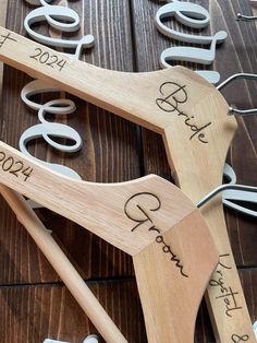 two wooden spoons with wedding date names on them sitting next to scissors and wire