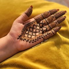 a woman's hand with henna tattoos on it