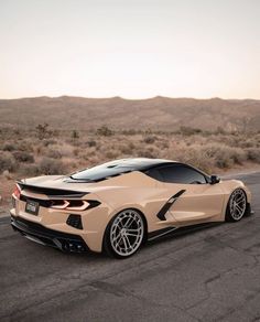 a beige sports car driving down the road