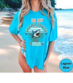 Discover our In my Shark tooth Era Comfort Colors beach vacation unisex shirt! This t-features a Retro colorful graphic. It shirt is super soft and comfortable made of 100% ring-spun ethically grown cotton. It has a relaxed fit that is made of a medium fabric that is preshrunk. Looks super cute with shirts, jeans or size up 1-3 sizes for an oversized beach cover up. Great gift idea for a Shark Tooth lover! Comes in 13 pretty colors!  💠PRINT: This is a handmade, Direct-to-Garment printed item. T Fun Beach T-shirt With Sublimation Print, Funny Blue T-shirt For Summer, Blue Summer T-shirt With Funny Text, Blue Funny Text T-shirt For Summer, Funny Beach T-shirt With Print, Fun Custom Print Beach T-shirt, Fun Beach T-shirt With Custom Print, Fun Sublimation Print T-shirt For Beach, Fun Custom Print T-shirt For The Beach