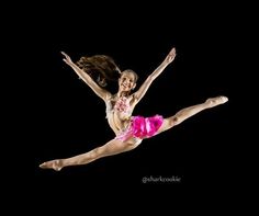 a woman in pink and white is doing a dance pose with her legs spread out