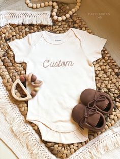 Party Crown Crafts offers premium embroidered bodysuits that are perfect for pregnancy announcements, birth announcements, hospital bring-home outfits, photo props, flat-lays, and personalized baby shower gifts and more. Bodysuits are supplied through Gerber-- ONESIES® Brand trademark is owned by Gerber Childrenswear LLC - Gerber Brand Premium 100% cotton interlock fabric, extremely soft, warmer than cotton rib, and holds the perfect amount of stretch - Certified with STANDARD 100 by OEKO-TEX® so that you don't have to worry about harmful substances in your baby's clothing - Short Sleeves and Long-Sleeves - Designed for easy changes with expandable lap shoulder necklines & two high-positioned bottom snaps. - 2 Colors available: White and Cream - 4 Sizes available: 0-3 months, 3-6 months, 6 Pink Cotton Baptism Onesie, Customizable Cotton Onesie For First Birthday, Personalized Fitted Onesie For Gender Reveal, Personalized Cotton Onesie For Baptism, Cotton Onesie For Baptism, Personalized Fitted Onesie For Baptism, Customizable Cotton Bodysuit For Family Matching, Cotton Baptism Onesie With Short Sleeves, Customizable Fitted Onesie