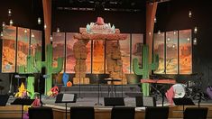 a stage set up for a concert with cactus decorations and instruments on the sidelines