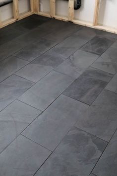 a kitchen with gray tile flooring and wooden cabinets