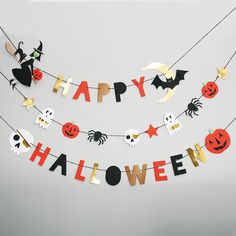 a happy halloween banner hanging from a string with bats, jack - o'- lanterns and pumpkins