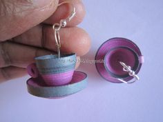 a miniature tea cup and saucer is being held by someone's hand