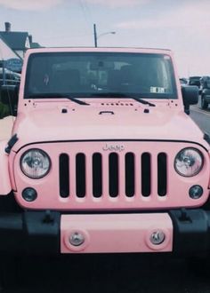 a pink jeep is parked on the side of the road