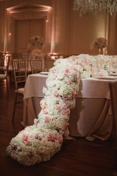 the table is covered with flowers and chairs are set up for an elegant wedding reception