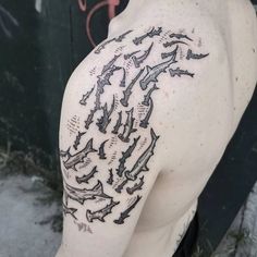 the back of a man's shoulder with many birds on it