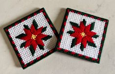 two red and green christmas poinsettis are on the white tablecloth next to each other