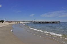 there is a long pier that extends into the water from the beach to the ocean