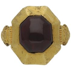 Medieval garnet cabochon ring. Set to centre with a single octagonal cabochon natural unenhanced garnet in a closed back rubover setting with an approximate weight of 8.00 carats, to an octagonal 'pie-dish' bezel design, leading to intricately carved shoulders and flowing through to a solid shank. Tested yellow gold, circa 1200-1400 century. Accompanied by documentation from the Portable Antiquities Scheme stating that this ring was found whilst metal detecting cultivated land in the Kingswood a Ancient Rings, Hand Engraved Rings, Spessartite Garnet, Engraved Plaque, Buckle Ring, Gem Diamonds, Gold Belts, Victorian Rings, Gold Signet Ring