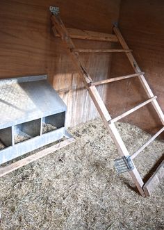 a ladder leaning up against the side of a barn filled with hay