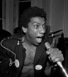 a black and white photo of a man singing into a microphone