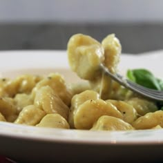 a white plate topped with pasta and spinach