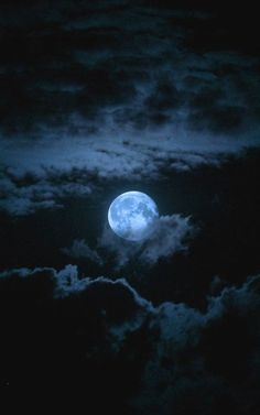 the full moon shines brightly in the night sky above clouds and trees on a cloudy day