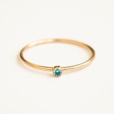 Our December Birthstone Ring features a gorgeous blue topaz-colored cubic zirconia. This dainty ring will be sure to add some sparkle to your everyday look. It makes the perfect gift for anyone with a December birthday, or anyone you'd like to remind that they are loved. Create your very own unique ring stack by stacking the birthstone rings of your loved ones! DETAILS 14k gold filled ring 1mm band with 2mm topaz-colored cubic zirconia Available in sizes 5-10 Matching jewelry: December Birthston December Birthstone Ring, Love Knot Ring, Dot Ring, Birthstone Rings, December Birthday, Topaz Color, Ring Stack, Gold Filled Ring, Bohemian Rings