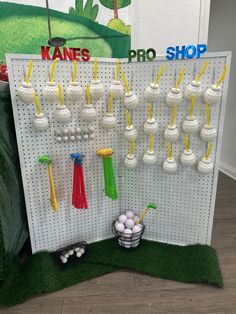 a peg board with golf balls, tees and cups on it in front of a wall display