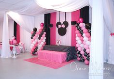 a minnie mouse themed birthday party with pink, black and white balloons on the ceiling